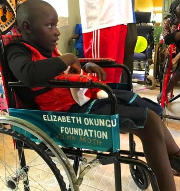 A boy starting to be happy with his new wheelchair.